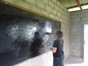 Cindy putting second of paint on blackboard