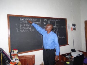 computer teacher Simon Liwolo explaining basics on the blackboard