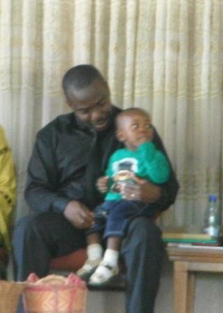 Our pastor and his young son listening while his wife leads the choir.
