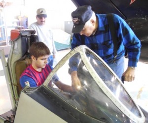 Our guide at the Combat Air Museum in Topeka shows Nate around the fighter jet cockpit.