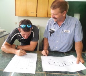 Athletic Director, Jordan, looks over plans for a covered gym with Ron