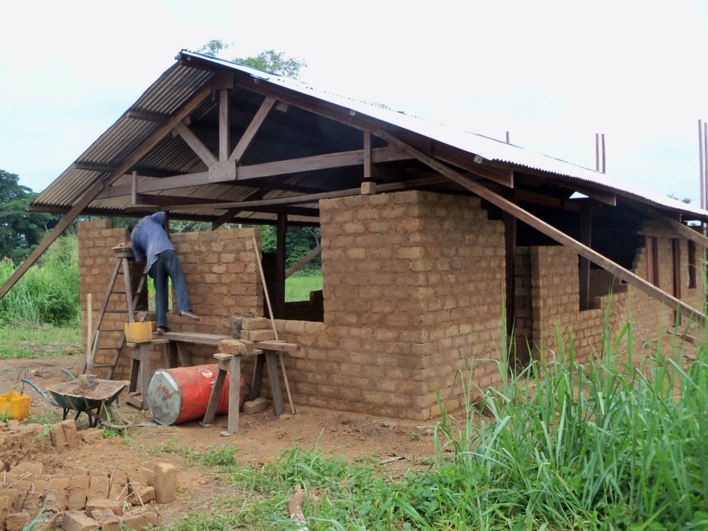 the mason hard at work laying the mud bricks on the duplex which will house the disciple families
